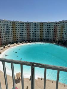 a large swimming pool in front of a large building at Chalet In Golf Porto Marina Sia Lagoon in El Alamein