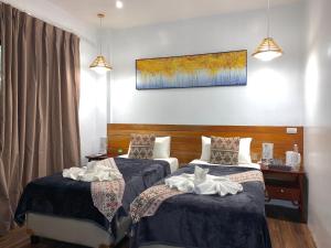 Infinity Diving Resort and Residences في داوين: غرفة فندقية بسريرين ولوحة على الحائط