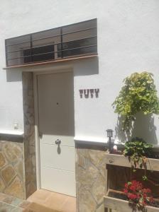 un edificio blanco con una puerta y una señal que dice furia en Tuty, en Málaga