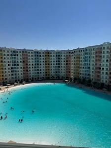 a large swimming pool in front of a large apartment building at Chalet In Golf Porto Marina Sia Lagoon in El Alamein