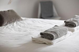 2 toallas sentadas encima de una cama blanca en Vakantiehuis Paula en Watervliet