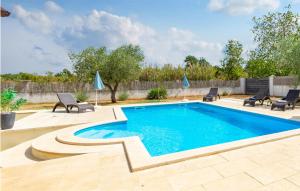 a swimming pool with two chairs and a patio with at Awesome Home In Mihelici With Wifi in Buici