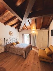a bedroom with a bed and a couch and wooden ceilings at L'Antico Asilo in Stazzema
