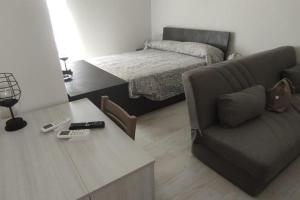 ein Wohnzimmer mit einem Sofa und einem Bett in der Unterkunft Vico del Teatro in Formia