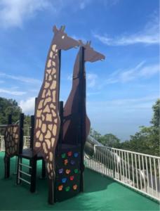 two giraffes are standing next to a chair at Wenzhou Ban Hotel in Banping