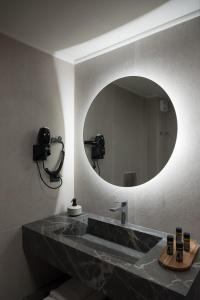 a bathroom with a sink with a large mirror at Nancy - Chara Apartments in Karteros