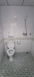 a bathroom with a toilet and a tiled floor at KANPAI HOTEL in Patong Beach