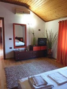 1 dormitorio con cama y espejo en Eni's Villa, 5km From Shengjini Beach, en Lezhë