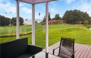 a screened in porch with a bench and a large window at Beautiful Home In Sjernary With House Sea View in Nedstrand