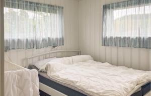 a white bed in a room with a window at Beautiful Home In Sjernary With House Sea View in Nedstrand