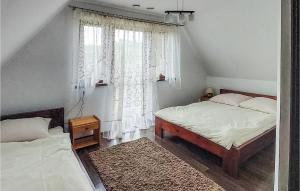 a bedroom with two beds and a window at Awesome Home In Lesko With Kitchen in Lesko