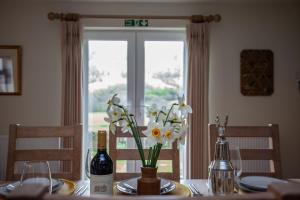 a dining room table with a vase of flowers on it at Kennels Cottage in Killin