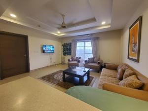 een woonkamer met een bank en een salontafel bij Private 1-Bedroom Apartment in Rawalpindi