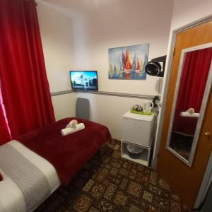 ein Hotelzimmer mit einem roten Vorhang und einem Bett in der Unterkunft St Albans Guest House, Dover in Dover