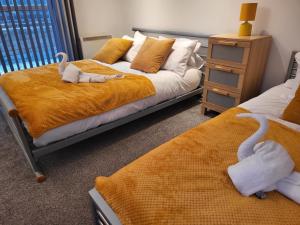 Luxury 2 Bed Apt On River, WiFi, Parking, Garden في مانشستر: غرفة نوم بسريرين عليها بجعات