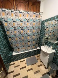 a bathroom with a shower curtain and a toilet at Pilar Hostel - Rua de Santa Catarina - Porto in Porto