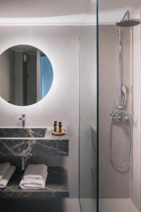 a bathroom with a shower and a sink and a mirror at Nancy - Chara Apartments in Karteros