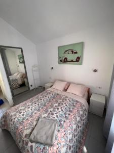 コスタ・カルマにある25Bのベッドルーム1室(ベッド1台付)が備わります。壁に車の写真が飾られています。