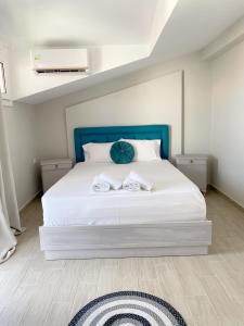 a bedroom with a bed with two towels on it at Delia Apartments in Pefkohori