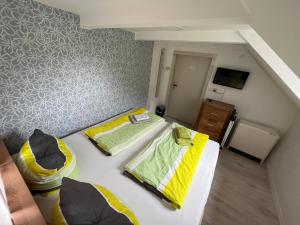 Habitación pequeña con 2 camas y TV. en Pension Alpenrose, en Bad Schandau