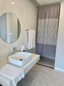 La salle de bains est pourvue d'un lavabo, d'un miroir et d'une douche. dans l'établissement Room in Wyndham Thanh Thuy Hot Spring MyHome, à La Phu
