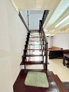 a staircase in a room with a rug on the floor at บ้านเช่า Wilai Townhome Udon in Udon Thani