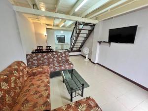 uma sala de estar com sofás e uma televisão de ecrã plano em บ้านเช่า Wilai Townhome Udon em Udon Thani
