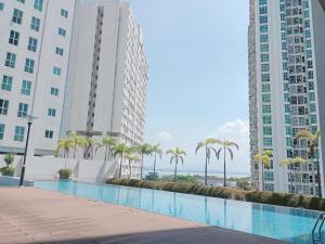 a swimming pool in the middle of two tall buildings at Deluxe Suites 4, 2-5 pax, Netflix, Georgetown in Jelutong +5 photos