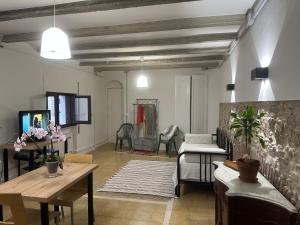 ein Wohnzimmer mit einem Sofa und einem Tisch in der Unterkunft NOTARIA-Apartamento y Estudio en casco antiguo, al lado de playa, Rambla y Monasterio, con acceso a terraza ajardinada in Sant Feliu de Guixols