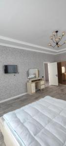 um quarto com uma cama branca e uma televisão na parede em Luxury Millionere villa em Gabala