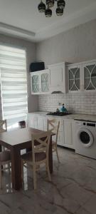 a kitchen with white cabinets and a table and chairs at Luxury Millionere villa in Gabala