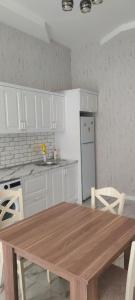 uma cozinha com uma mesa de madeira e armários brancos em Luxury Millionere villa em Gabala