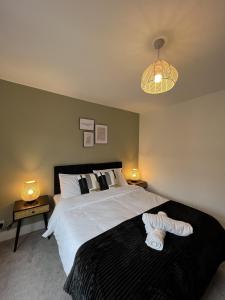 a bedroom with a large white bed and two lamps at Warner Brothers House in Watford