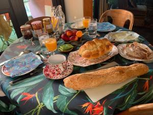 uma mesa com pequeno-almoço de pão e sumo de laranja em Chambre d'hôtes Fauvart Antony Réal em Orange