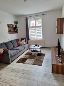 a living room with a couch and a table at Fewo Am Marktplatz II in Eisenhüttenstadt