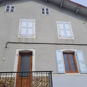 a building with three doors and a balcony at Appartement T 1bis in Saint-Geoire-en-Valdaine