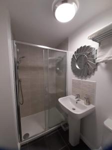 a bathroom with a shower and a sink and a mirror at Beautiful 4 Bedroom Treasure home in Hemel Hempstead