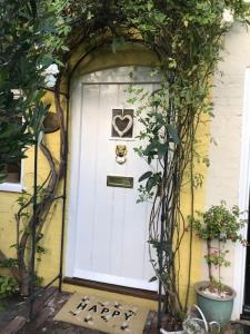 a white door with a heart sign on it at Boutique style cottage Bridgnorth in Bridgnorth