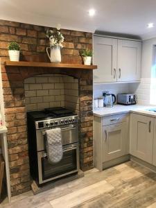 a kitchen with an oven and a brick wall at Boutique style cottage Bridgnorth in Bridgnorth