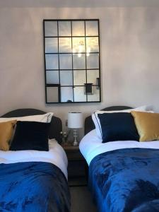 a bedroom with two beds and a mirror on the wall at Boutique style cottage Bridgnorth in Bridgnorth
