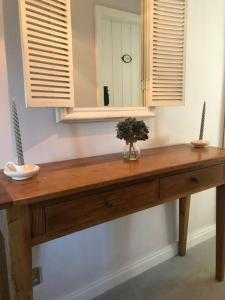 una mesa de madera en una habitación con espejo en Boutique style cottage Bridgnorth, en Bridgnorth