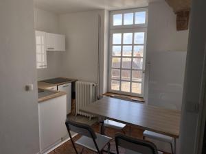 a kitchen with a table and chairs and a window at Hôtel Particulier de Champrond in Chartres