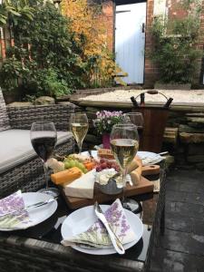 una mesa con copas de vino y comida. en Boutique style cottage Bridgnorth, en Bridgnorth