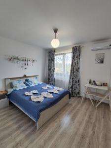 Un dormitorio con una cama azul y una ventana en Happy Home, en Călimăneşti