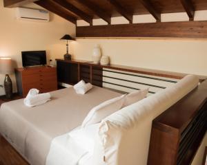 una camera da letto con un grande letto bianco e una televisione di Residenza Sweet Juliet a Verona