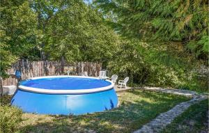 ein blauer Pool in einem Garten mit zwei Stühlen in der Unterkunft Lovely Home In Marsanne With Outdoor Swimming Pool in Marsanne