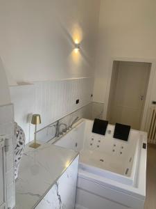 uma casa de banho branca com banheira num quarto em Geometric Hermes Bianca em Palo del Colle