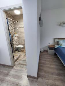 a white room with a bathroom with a bed and a shower at Happy Home in Călimăneşti