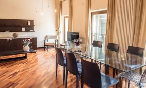 una sala da pranzo con tavolo in vetro e sedie di Residenza Sweet Juliet a Verona