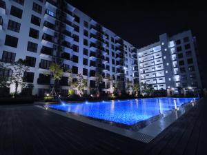 a large swimming pool at night with buildings at Armadale Galacity Minimalist 3 Bedrooms Entire Apartment in Kuching